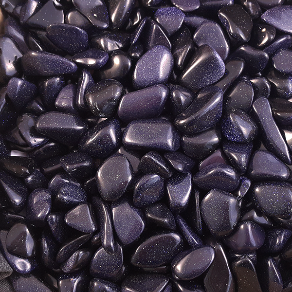 A polished cobalt-blue goldstone sphere flecked with thousands of tiny sparkling copper points, resembling a starry night sky.