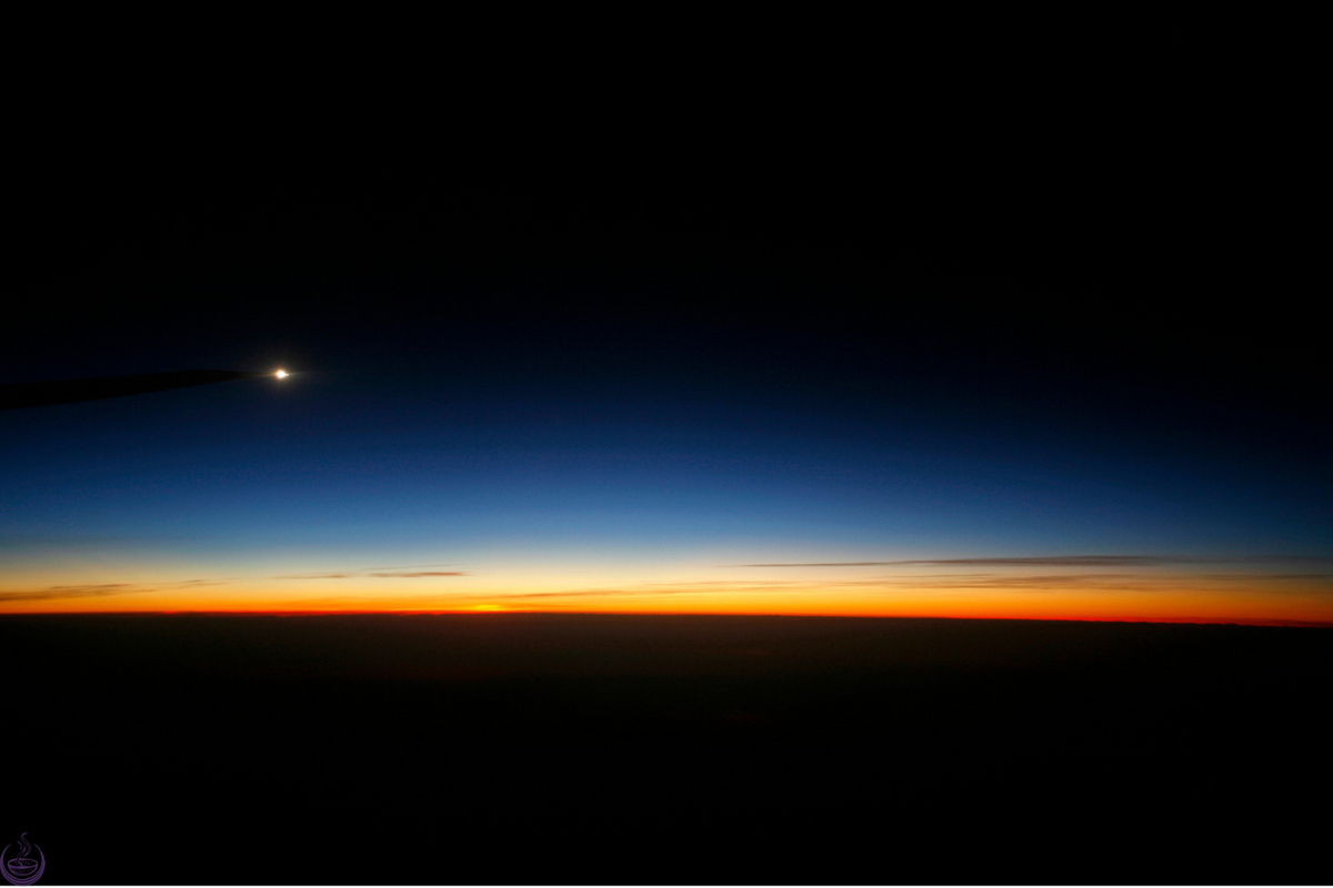 A single bright planet above the first glow of dawn on the horizon