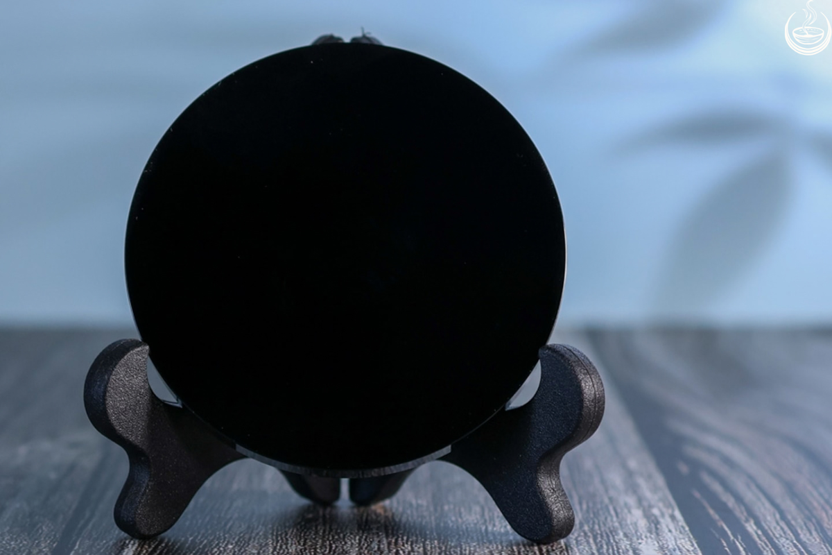 Black obsidian scrying mirror on a wooden stand