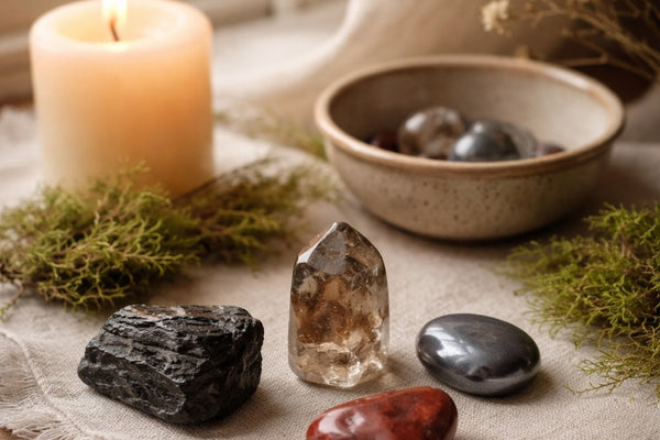 Grounding crystals arranged in a calm ritual space with candlelight and natural textures