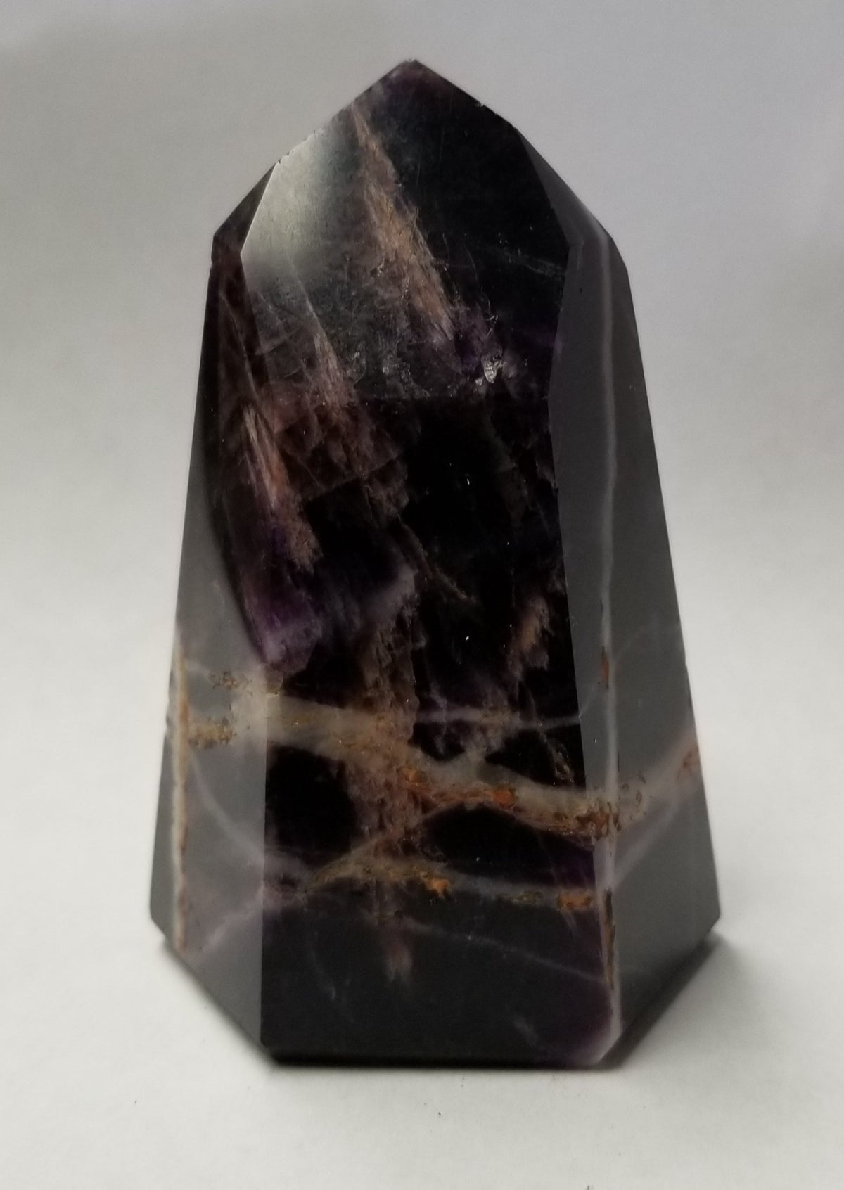 Super Seven crystal showing amethyst, smoky quartz, and cacoxenite inclusions