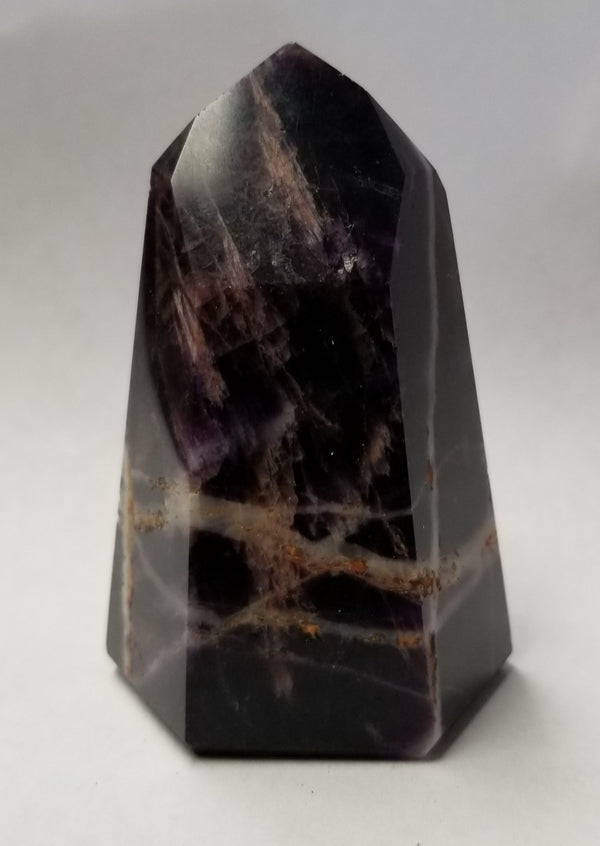 Super Seven crystal showing amethyst, smoky quartz, and cacoxenite inclusions
