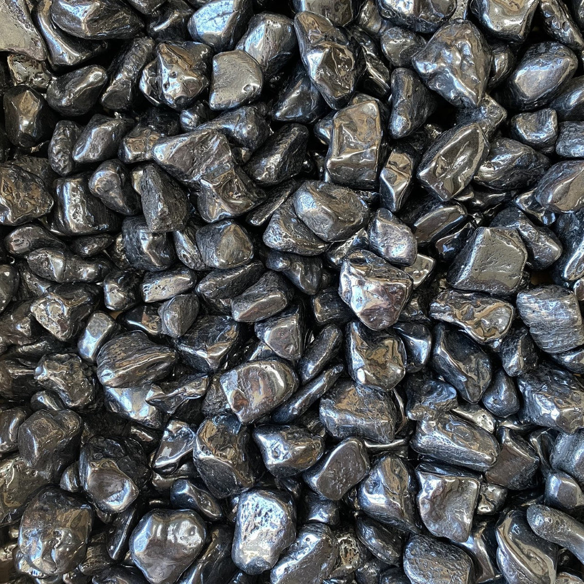 A dense, dark steel-grey to black manganese ore nugget with a rough, botryoidal surface and a metallic-to-dull luster.