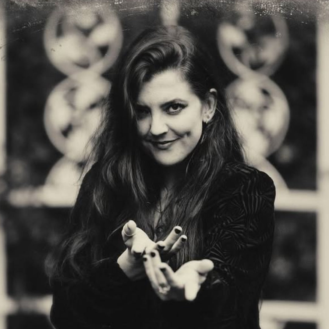 Black and white portrait of Asia Ray with blurred statues in the background