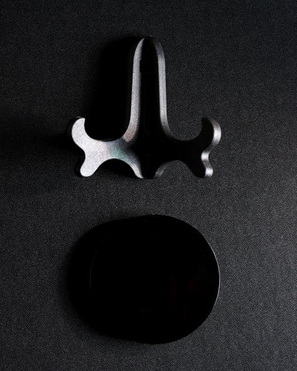 Obsidian scrying mirror shown beside its separate easel stand