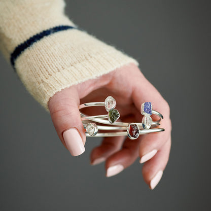 Two-stone sterling silver cuff bracelets worn on a wrist