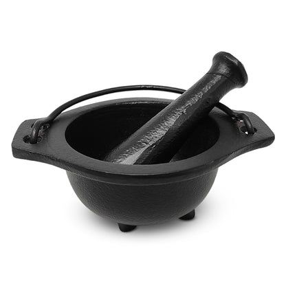 Black cast iron cauldron with pestle