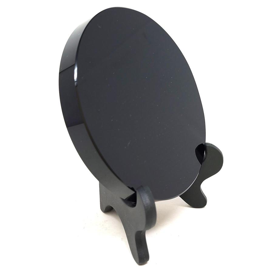 Obsidian scrying mirror on a black easel stand, angled view