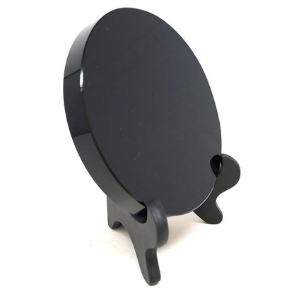 Obsidian scrying mirror on a black easel stand, angled view