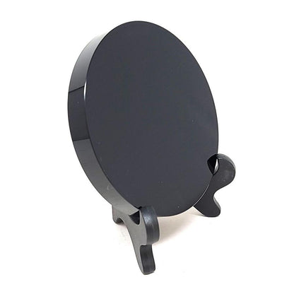 Obsidian scrying mirror and stand on a plain white background