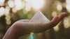 Hand holding crystal pyramid 